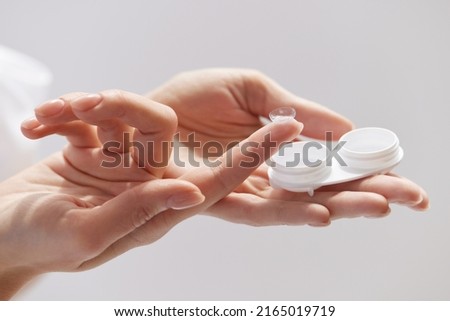Contact Eye Lenses. Woman Hands Holding Contact Eye Lens. Woman Hands Holding White Container. Beautiful Woman Fingers Holding Eye Lens Box. Health And Eyes Care Concept. High Resolution Royalty-Free Stock Photo #2165019719