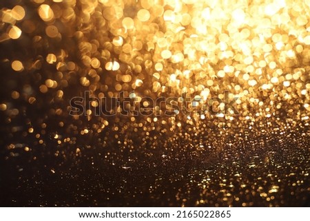 Golden shiny glitter lights from water drops. Abstract background for christmas, celebratios, partys and more