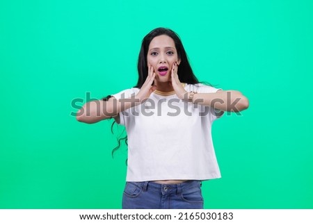 Portrait of amazed shocked Beautiful Indian girl or Young south Asian woman over green background. Surprised young woman hands on face. surprised young lady laughing and holding her hands near cheeks