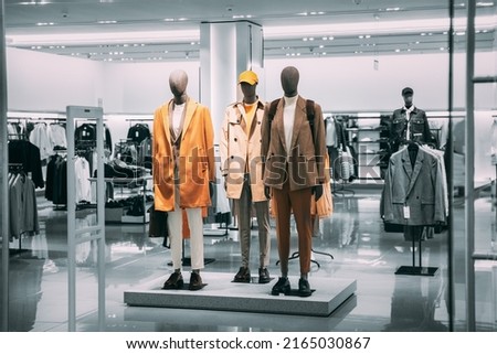 Mannequins Dressed In Men male Casual Clothes And coat jackets Clothes In Store Of Shopping Center. Stack clothes In Store Of Shopping Center. shelf display in shop mall store. Store Of Shopping Royalty-Free Stock Photo #2165030867