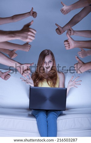Image of excited facebook girl sitting on couch Royalty-Free Stock Photo #216503287