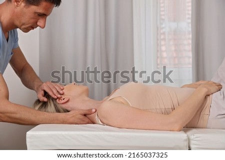 Chiropractic adjustment or neck stretch massage for female patient . Pain relief concept Royalty-Free Stock Photo #2165037325