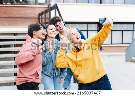 Exchange Student Friends having fun laughing and taking a selfie photo in a celebration in the University Campus