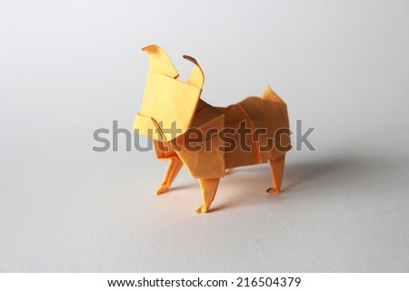 Orange paper origami pug isolated on white background