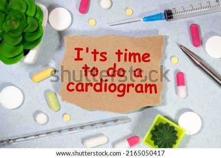 Medicine concept. On the table is a stethoscope, a pen and a notebook in which it is written - Its time to do a cardiogram