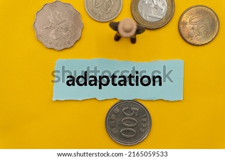 adaptation.The word is written on a slip of paper,on colored background. professional terms of finance, business words, economic phrases. concept of economy.