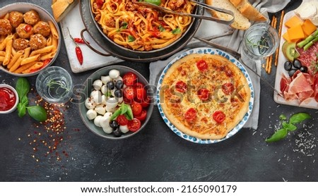 Italian food assortment on dark background. Traditional food concept. Dishes and appetizers of indeed cuisine. Flat lay, top view, copy space
