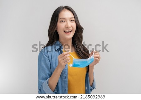 Portrait of cheerful asian young womon take off mask after getting anti virus vaccine covid-19 or pandemic, end country lockdown, unlock. Healthcare, immunity people isolated on white background. Royalty-Free Stock Photo #2165092969
