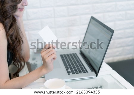 Business Asian woman using credit card shopping online with laptop computer. Beautiful businesswoman holding smart card for payment. Concept of business, technology, financial and online banking.