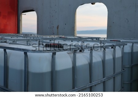 storage tanks, chemical tanks, clear colored and cube-shaped oil tanks, which contain dangerous liquids, are placed on the maindeck of supply ships to be sent to offshore drilling