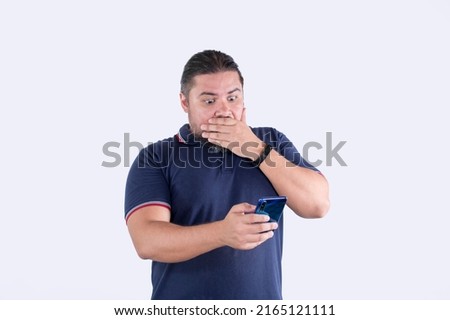 A man in his 30s watches in horror a scandalous or shockingly gory video on his phone. Isolated on a white background. Royalty-Free Stock Photo #2165121111