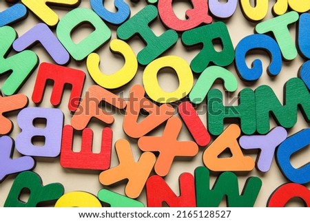 Colorful letters on beige background, closeup. Alphabet concept