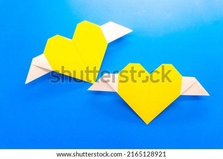 yellow origami heart on a blue background. love concept