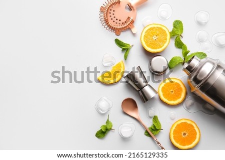 Different utensils and cocktail ingredients on grey background Royalty-Free Stock Photo #2165129335