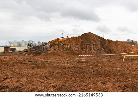Soil on earth as texture and background. Warning or protective tape at a construction site Royalty-Free Stock Photo #2165149533