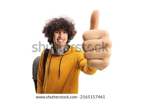 Cheerful male student carrying a backpack and gesturing a thumb up sign isolated on white background