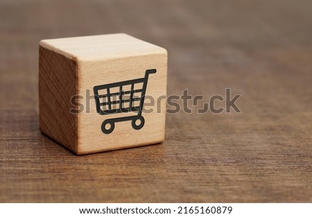 shopping cart icon on wooden cube block on the wooden floor, Online Shopping concept, sell marketing purchase delivery.                        