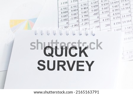 Quick Survey inscription on a notepad on the table next to reports and charts