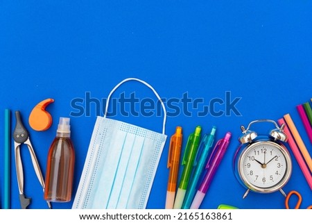 Back to school concept with school supplies on classic blue background
