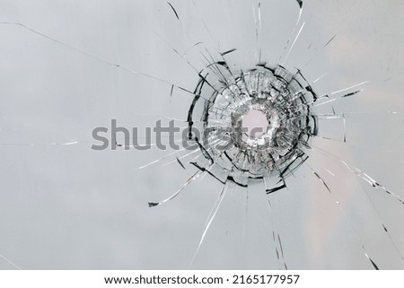 Bullet hole in the rock. Broken window, cracks. Abstract background or texture