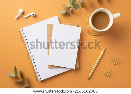 Business concept. Top view photo of workplace diary paper sheet envelope cup of coffee on wooden stand wireless earbuds gold pen binder clips eucalyptus on isolated orange background with empty space