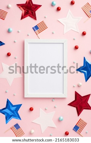 Fourth of July concept. Top view vertical photo of photo frame US national flags stars and scattered candies on isolated pastel pink background with empty space