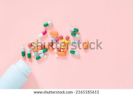 pills and pill bottles on pink background,Assorted pharmaceutical medicine pills, tablets and capsules and bottle on pink background. Top view. Flat lay. Copy space. Medicine concept. Heap of pills on Royalty-Free Stock Photo #2165185615