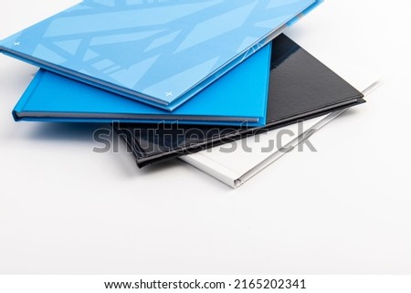 Pile of blue, black,white notebooks isolated on white background