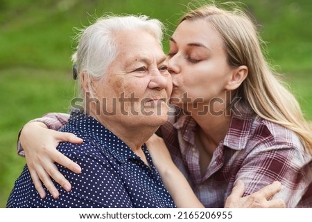 loving granddaughter kisses her grandmother on the cheek. The connection of generations, love in the family.