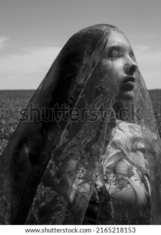 monochrome photograph of a portrait of a woman covered with a transparent cloth
