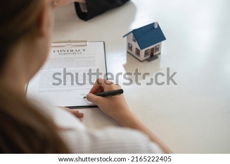 Buying houses and land, guarantees, contract and agreement, An employee of a real estate company hands over the house and keys after the contract for the sale of land and buildings is complete.