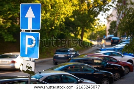 Rows of cars parked on roadside, parking sign. Cars parked on parking lot at downtown, parking problems not enough free space. Crowded public park zone on narrow street. Tight parking space Royalty-Free Stock Photo #2165245077