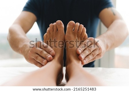 Masseur man during integrative medicine treatment - female foot massage Royalty-Free Stock Photo #2165251483