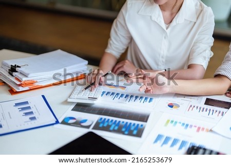financial, Planning, Marketing and Accounting, Asian young Economist using calculator to calculate investment documents with partners on profit taking to compete with other companies Royalty-Free Stock Photo #2165253679