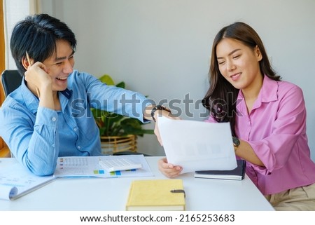 Negotiation, Analysis, Discussion, Portrait of an Asian young economist and marketer pointing to a financial data sheet to plan investments to prevent risks and losses for the company.