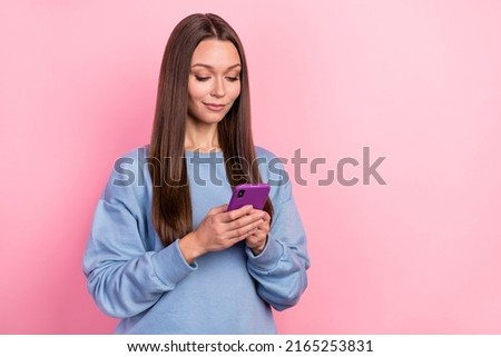 Portrait of attractive focused cheerful girl using device post smm app blogging isolated over pink pastel color background