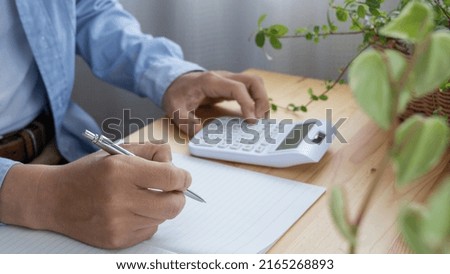 A man who keeps a household account book. Royalty-Free Stock Photo #2165268893