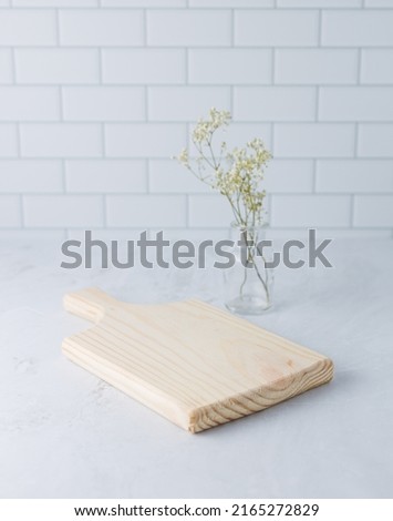 A cutting board is on the worktop in the kitchen. Vertical picture.
