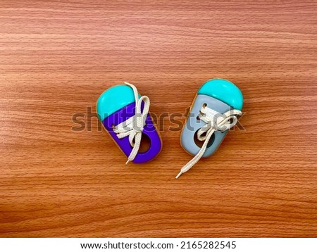 Top view pair of wooden sneakers toy shoe on the wooden background