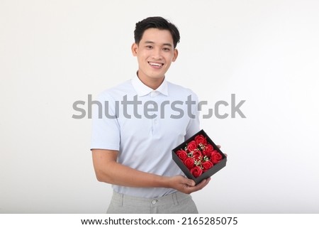Asian handsome young and cheerful man with gift box, isolated on white background