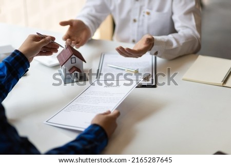 Real estate agents negotiate the terms of the home purchase contract and sign the contract legally. Home insurance concept.
