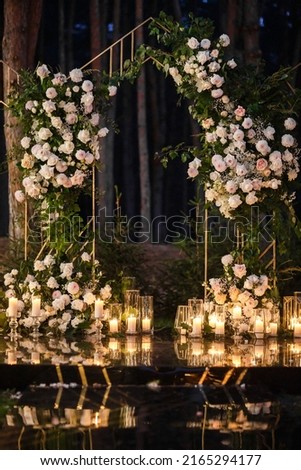 Arch for an outdoor wedding ceremony with candles. Royalty-Free Stock Photo #2165294177