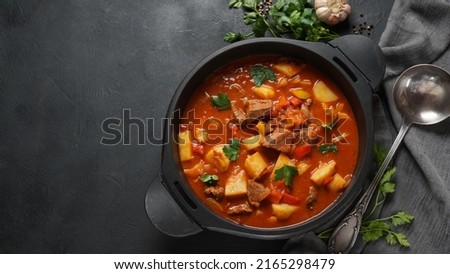 Beef goulash, soup and a stew, made of beef chuck steak, potatoes and plenty of paprika. Hungarian  traditional meal. Royalty-Free Stock Photo #2165298479