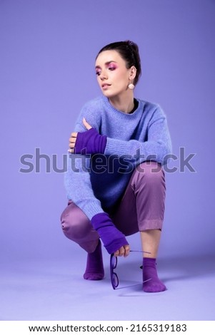 Portrait of lovely girl with violet purple outfit, isolated over violet purple background. Purple violet make-up.