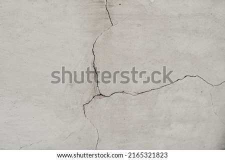 Old wall with white plaster and cracked peeling texture in black and white copy space. Grunge cracked concrete wall. Grungy wide brickwall. Royalty-Free Stock Photo #2165321823