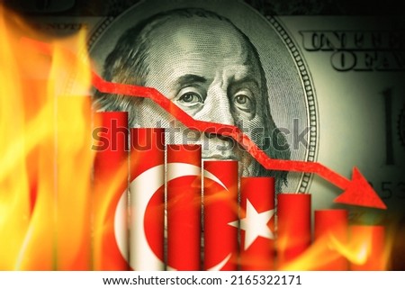 Devaluation of Turkish Lira against American dollar. Recession in Turkey concept. Financial crisis, inflation and collapse in Turkey. Red arrow going downwards above business graph in front of dollar. Royalty-Free Stock Photo #2165322171