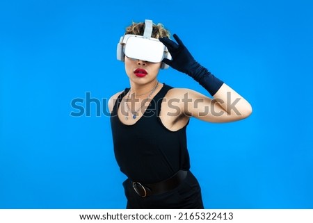 Metaverse concept, asian gay man in black tank top wearing vr headset posing on the blue screen background.