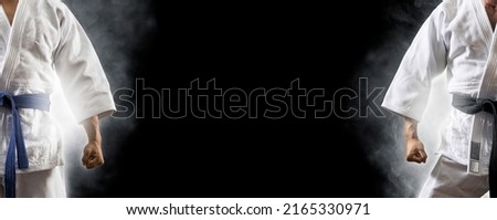 Man in white kimono with black belt.  Judo and karate concept Royalty-Free Stock Photo #2165330971