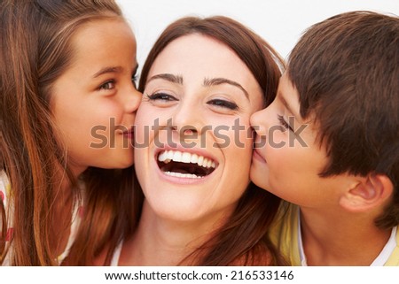 Portrait Of Hispanic Children Kissing Mother