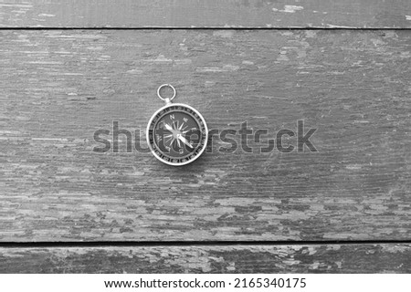 black and white photo of round compass as symbol of tourism with compass, travel with compass and outdoor activities with compass
